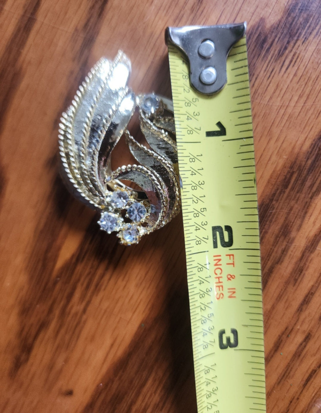 Elegant gold-tone Scarf Clip features sparkling rhinestones and a unique design