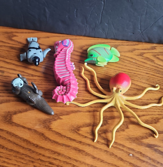 Bundle of 5 realistic sea animal toy figures. This set includes a yellow/redoctopus, a gray & Black seal, and a brown sea otter, fish & Seahorse.