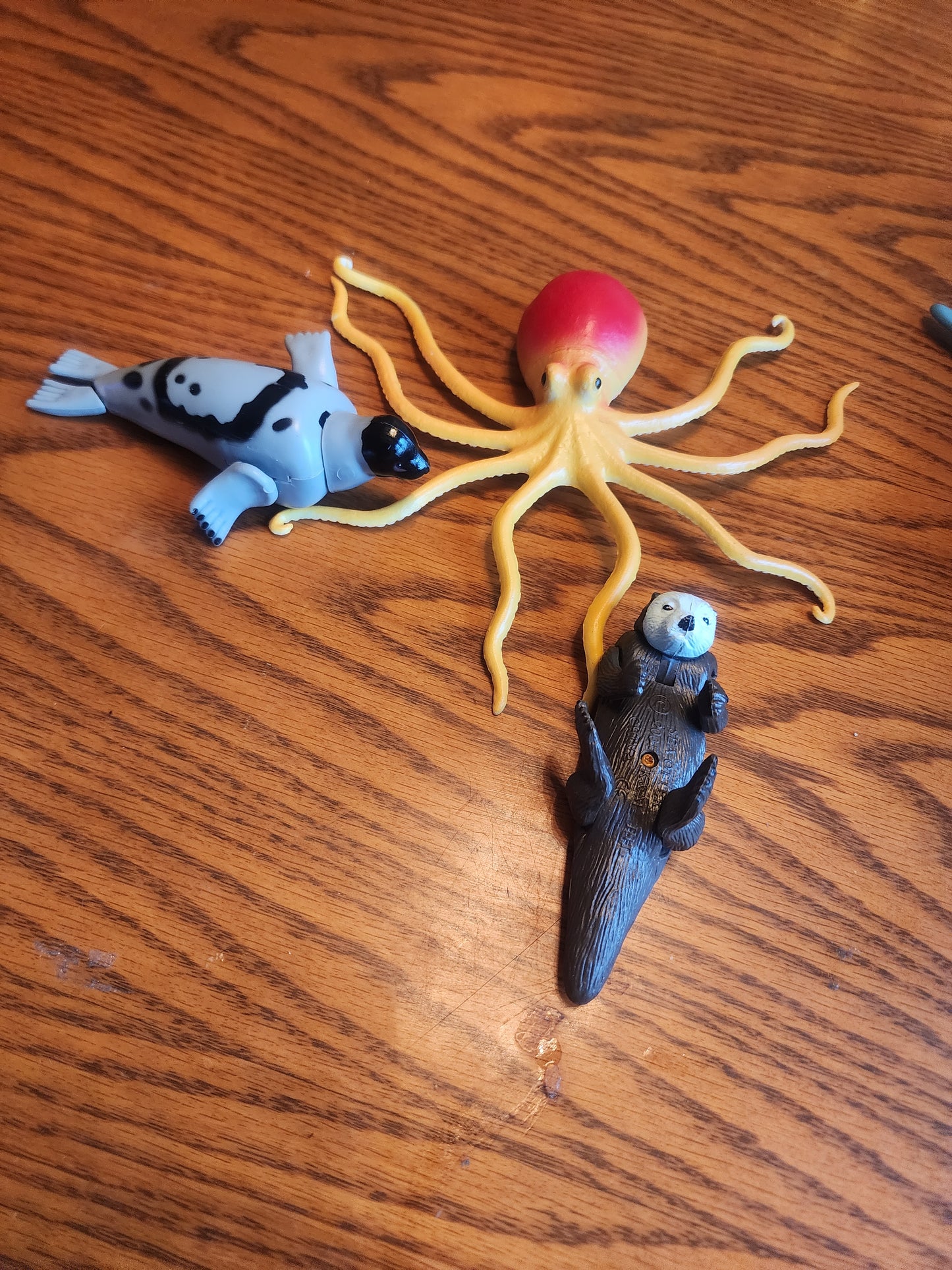 Bundle of 5 realistic sea animal toy figures. This set includes a yellow/redoctopus, a gray & Black seal, and a brown sea otter, fish & Seahorse.