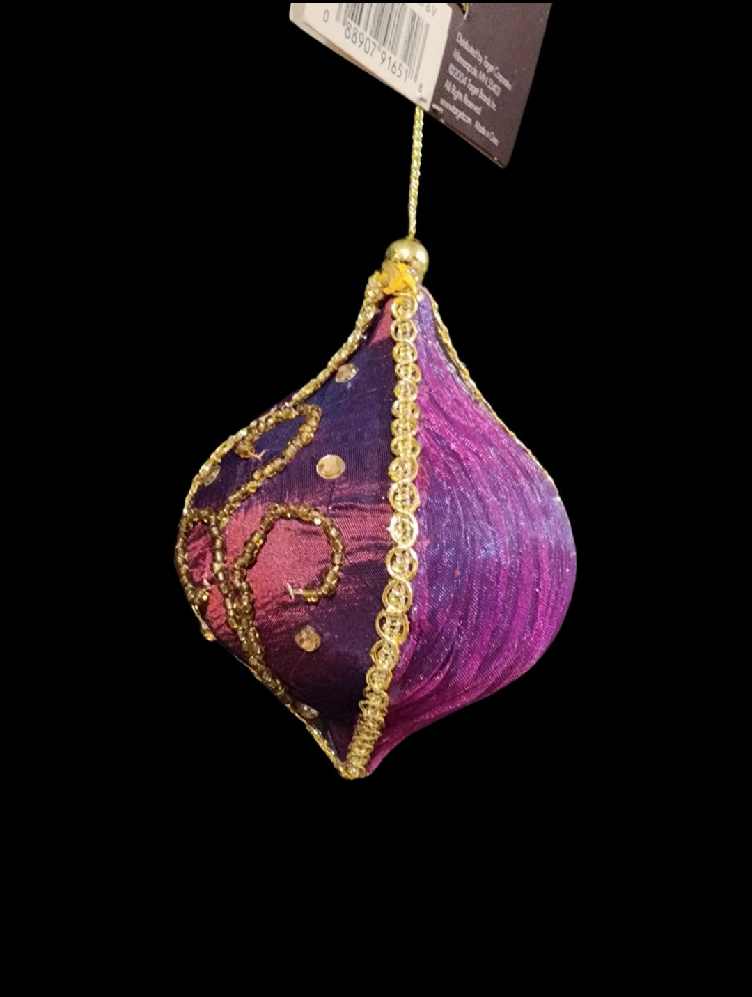 Purple ornament, made of fabric with gold-colored beading and faux gems