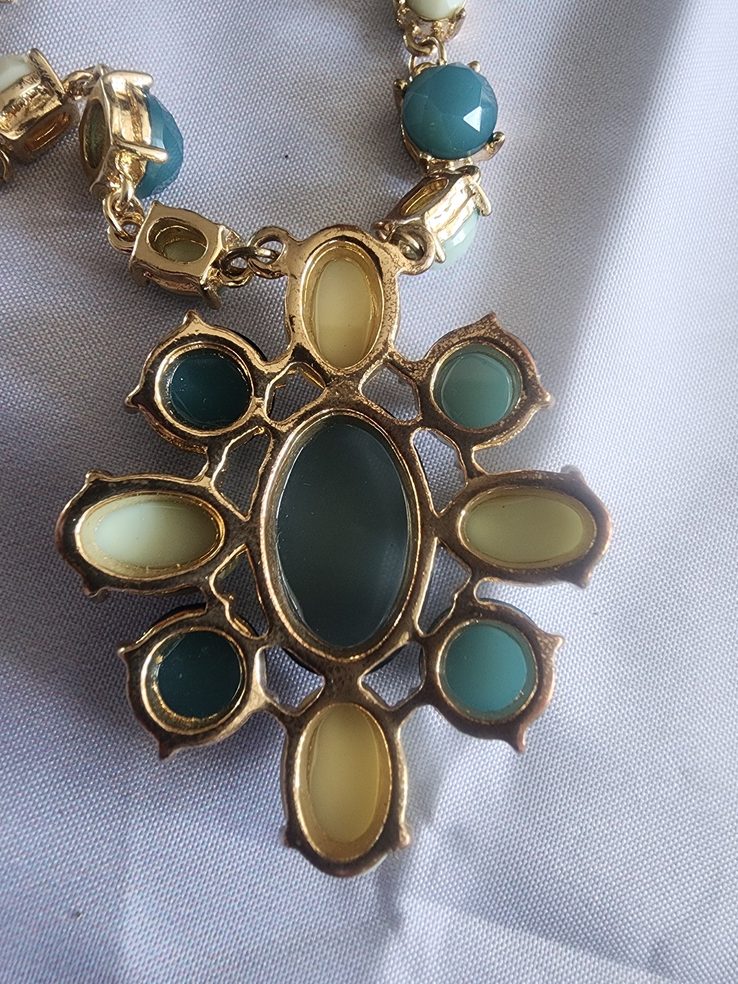 This vintage necklace features a stunning cluster of teal and cream stones